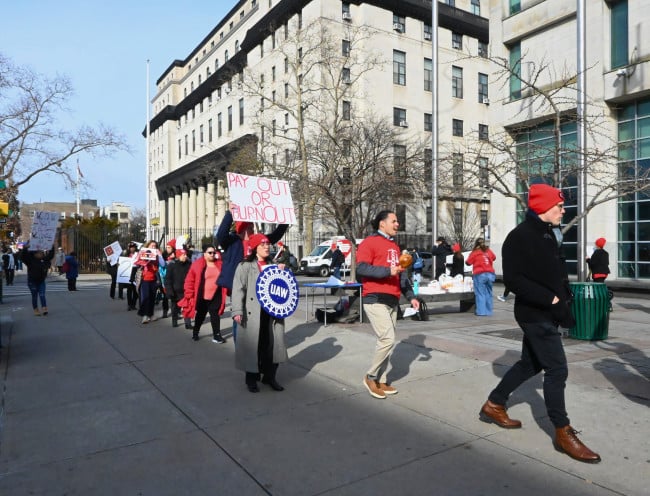 Union members march in a circle on Monday afternoon in front of Queens Civil Court.